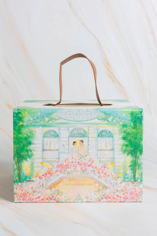 A luxury wedding invitation presented as a box with a hand painted design of a castle, flowers and trees.